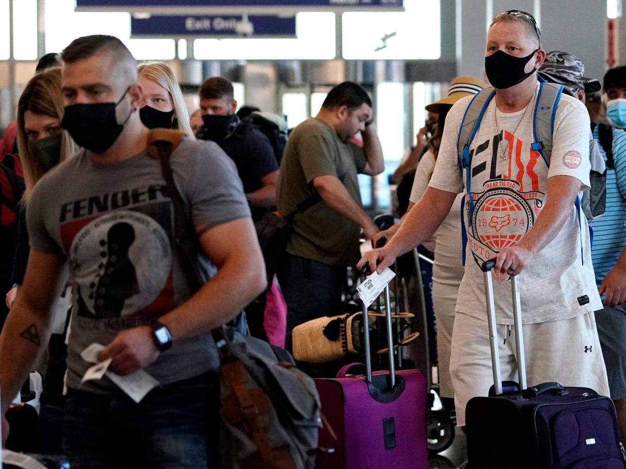 Travelers are lining up at O'Hare airport in Chicago, Friday, July 2, 2021.