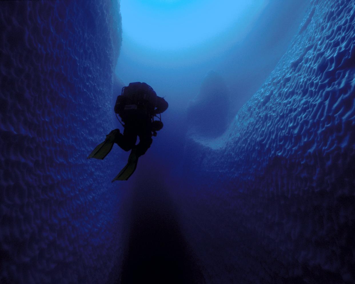 A scuba diver swimming inside an ice cave