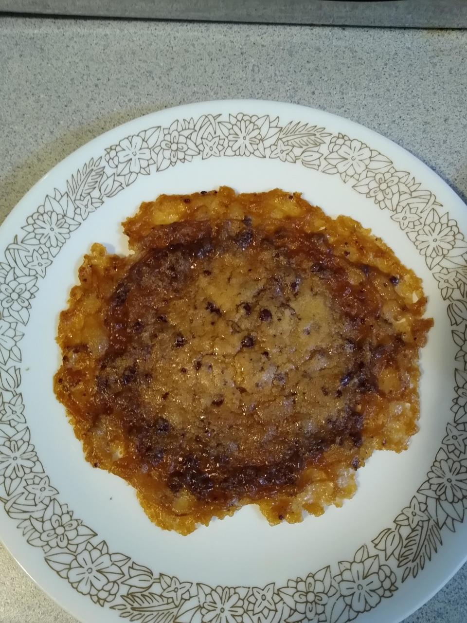 Homemade pancake with uneven cooking on a floral patterned plate