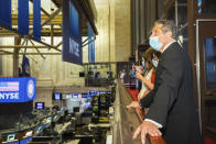 In this image provided by the New York Stock Exchange, New York State Gov. Andrew Cuomo looks over the floor of the New York Stock Exchange, Tuesday, May 26, 2020, in New York. Gov. Cuomo rang the opening bell at the NYSE Tuesday, which allowed a limited number of traders back to the floor. It required that traders adhere to social distancing guidelines and wear masks. (Colin Ziemer/New York Stock Exchange via AP)