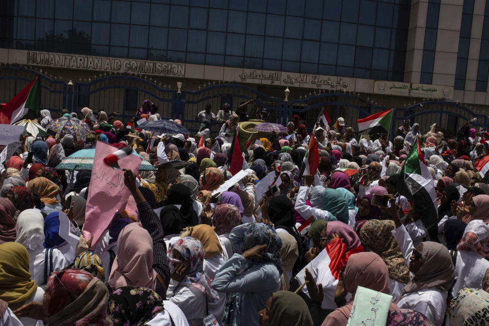 A group of protesters from the Sudanese medical profession syndicate march at the sit-in inside the Armed Forces Square, in Khartoum, Sudan, Wednesday, April 17, 2019. A Sudanese official and a former minister said the military has transferred ousted President Omar al-Bashir to the city's Kopar Prison in Khartoum. The move came after organizers of the street protests demanded the military move al-Bashir to an official prison. (AP Photos/Salih Basheer)