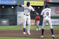 Houston Astros designated hitter Yordan Alvarez (44) celebrates his solo home run against the Los Angeles Angels with third base coach Gary Pettis (8) during the first inning of a baseball game Tuesday, May 21, 2024, in Houston. (AP Photo/Michael Wyke)