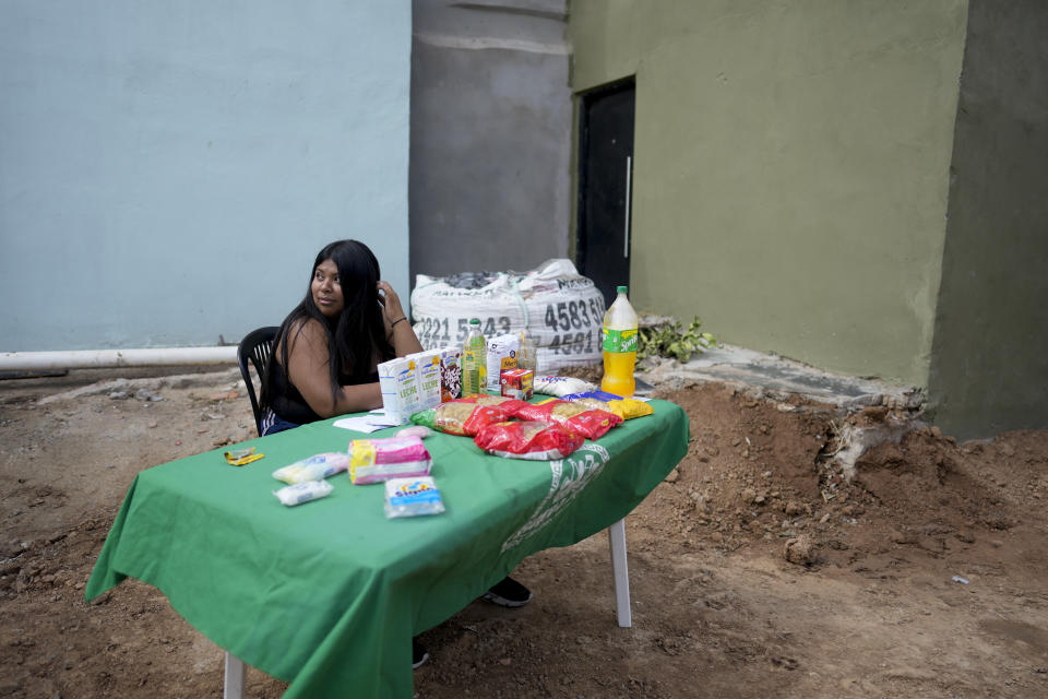 Janet, who works for the social movement Dignity, sits at a table offering food staples at lower prices than offered at the supermarkets, amid rising inflation, in Buenos Aires, Argentina, Thursday, March 16, 2023. (AP Photo/Natacha Pisarenko)