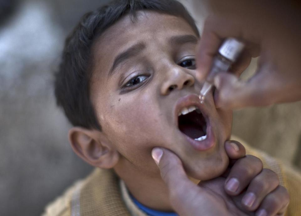 FILE- in this file photo dated Monday Nov. 25, 2013, a Pakistani child is vaccinated against polio by a health worker in Islamabad, Pakistan, Monday, Nov. 25, 2013. In an announcement Monday May 5, 2014, the World Health Organization (WHO) says the spread of polio is an international public health emergency that threatens to infect other countries with the crippling disease and could ultimately unravel the nearly three-decade effort to eradicate it, describing the ongoing polio outbreaks in Asia, Africa and the Middle East as an "extraordinary event" requiring a coordinated international response.(AP Photo/Muhammed Muheisen, FILE)