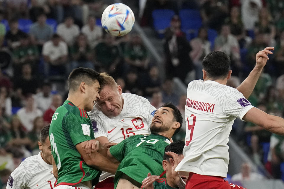 Poland's Kamil Glik and Mexico's Cesar Montes go for a header during a World Cup group C soccer match at the Stadium 974 in Doha, Qatar, Tuesday, Nov. 22, 2022. (AP Photo/Martin Meissner)