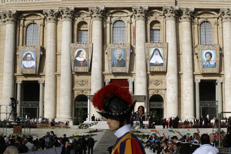 Tapestries hanging from the facade of St. Peter's Basilica portray from left, Dulce Lopes Pontes, Giuseppina Vannini, John Henry Newman, Maria Teresa Chiramel Mankidiyan, and Margarita Bays, in St. Peter's Square at the Vatican, Sunday, Oct. 13, 2019. Pope Francis canonizes Cardinal John Henry Newman, the 19th century Anglican convert who became an immensely influential thinker in both Anglican and Catholic churches, and four other women. (AP Photo/Alessandra Tarantino)