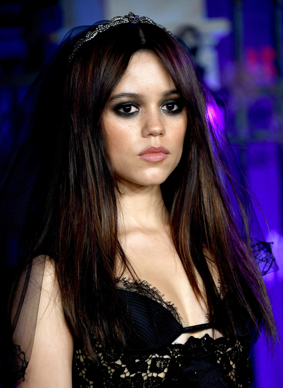 Close-up of Jenna wearing a tiara and dramatic eye makeup, with a bra lace top