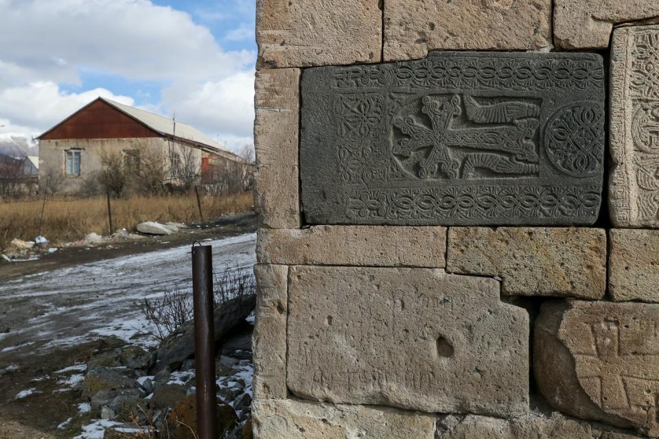 A stone with intricate cross inscription in the facade of a stone building