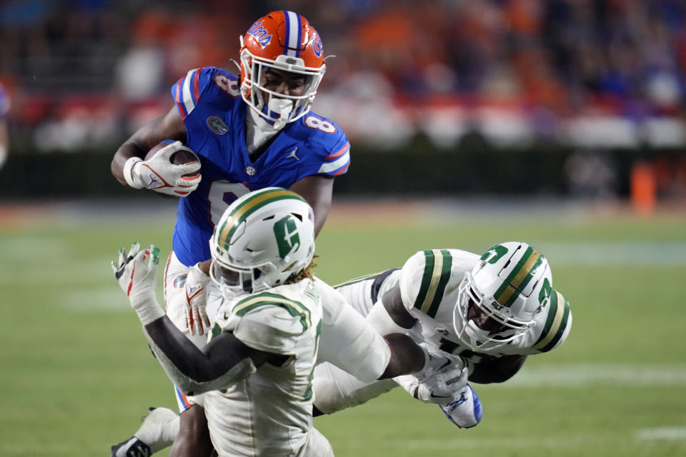 Florida tight end Arlis Boardingham (8) is tackled by Charlotte defensive back Isaiah Hazel, right, and linebacker Demetrius Knight II, front left, after a reception during the second half of an NCAA college football game, Saturday, Sept. 23, 2023, in Gainesville, Fla. (AP Photo/John Raoux)