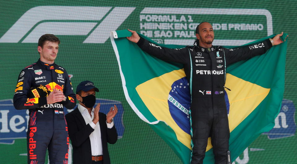 Mercedes' Lewis Hamilton (pictured right) celebrates on the podium after winning the race alongside second placed Red Bull's Max Verstappen.