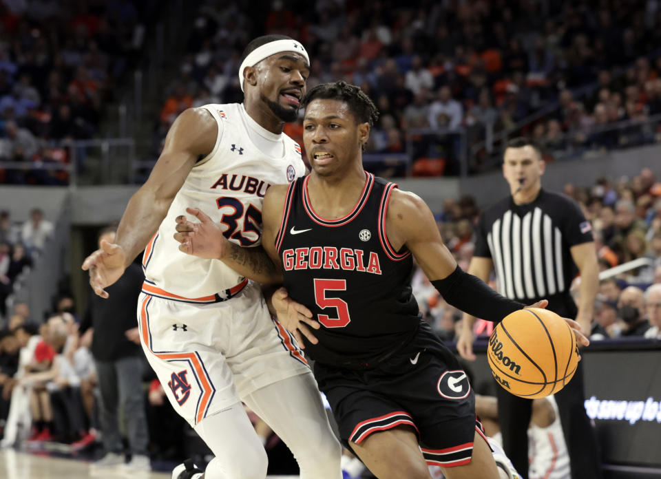 Georgia guard Christian Wright (5) is fouled by Auburn guard Devan Cambridge (35) as he goes to the basket during the first half of an NCAA college basketball game Wednesday, Jan. 19, 2022, in Auburn, Ala. (AP Photo/Butch Dill)