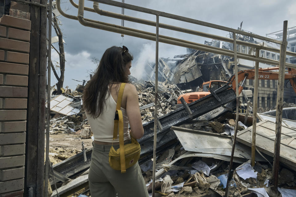 A woman watches as emergency service personnel work at the site of a destroyed building after a Russian attack in Odesa, Ukraine, Thursday, July 20, 2023. Russia pounded Ukraine’s southern cities, including the port city of Odesa, with drones and missiles for a third consecutive night in a wave of strikes that has destroyed some of the country’s critical grain export infrastructure. (AP Photo/Libkos)
