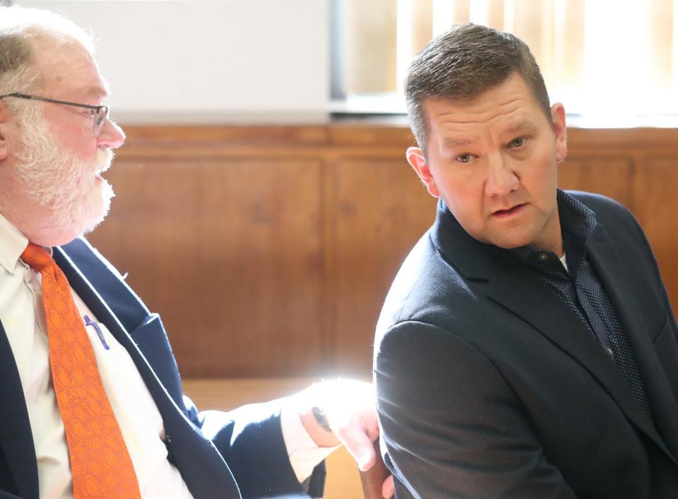 Defense attorney Mike Callahan talks to former state Rep. Bob Young after Young was found guilty of domestic violence and acquitted of assault by Visiting Judge Edward O'Farrell in Barberton Municipal Court on Thursday.