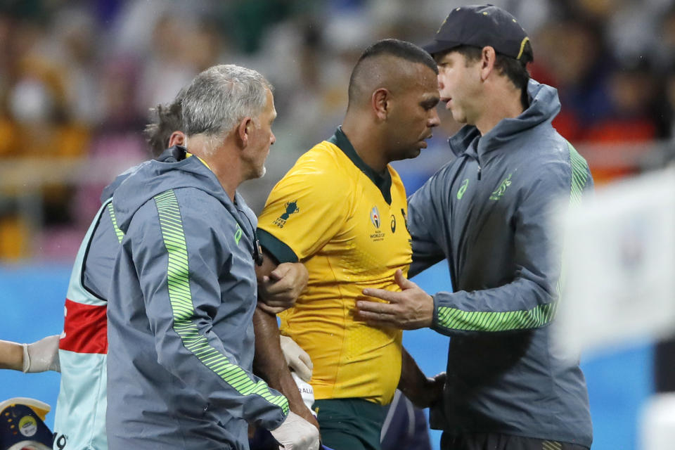 FILE - In this Oct. 11, 2019,file photo, Australia's Kurtley Beale, center, is assisted from the field after suffering a head injury during the Rugby World Cup Pool D game at Shizuoka Stadium Ecopa between Australia and Georgia in Shizuoka, Japan. A "shadow trial" of advanced eye-tracking technology will be conducted in the Trans-Tasman Super Rugby tournament in Australia and New Zealand as part of World Rugby's bid to tackle head injuries by improving the detection of concussion. (AP Photo/Christophe Ena, File)