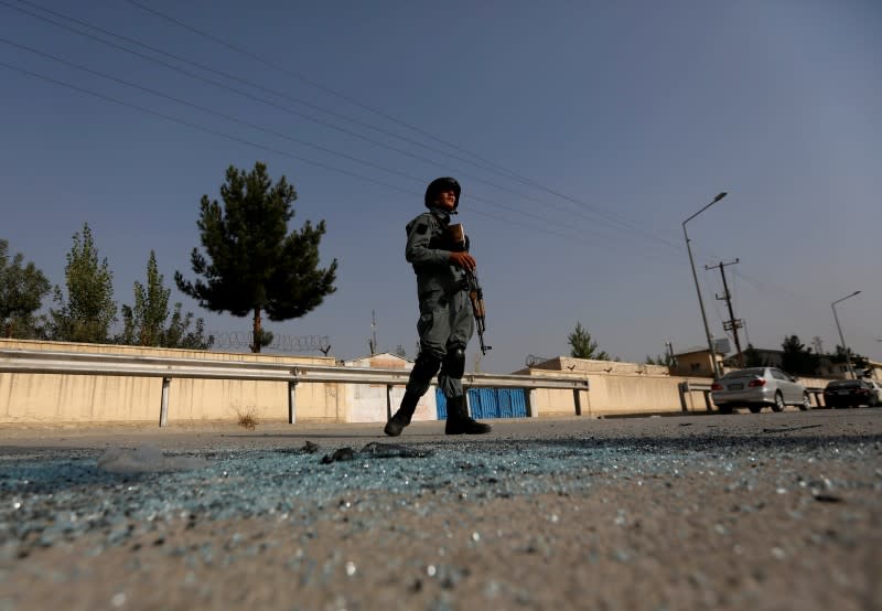 Policier afghan près de l'université américaine de Kaboul où douze personnes sont mortes et 44 autres ont été blessées après une attaque mercredi soir. /Photo prise le 25 août 2016/REUTERS/Mohammad Ismail