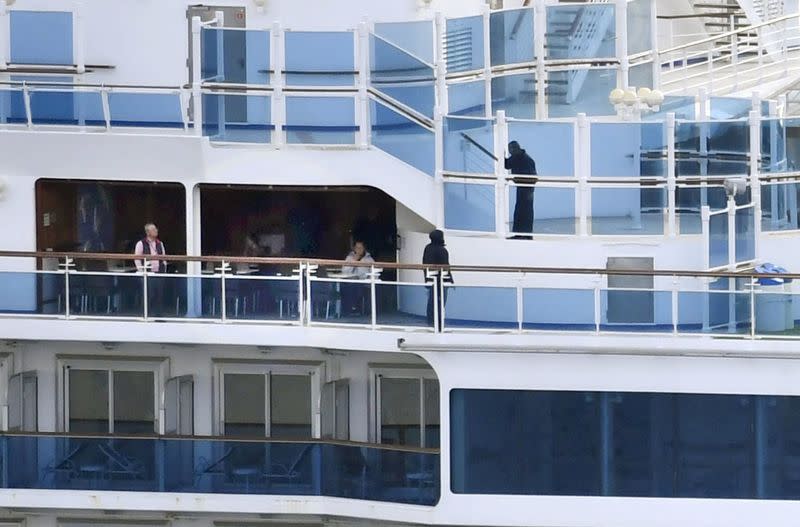 People on board cruise ship Diamond Princess anchored off the Yokohama Port, are pictured in Yokohama