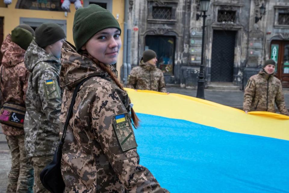 A cadet helps hold a huge Ukrainian flag during the National Anthem Day celebration at Rynok Square in Lviv, Ukraine, in March as the country celebrates the 159th anniversary of the first public performance of the National Anthem of Ukraine.