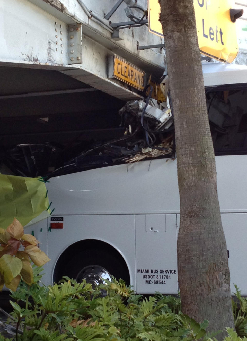 A bus is lodged into an overpass at the Miami International Airport on Saturday, Dec. 1, 2012. The vehicle was carrying over 30 people when it crashed into the structure. Authorities say buses typically are routed through the departures area, which has a higher clearance. (AP Photo/Suzette Laboy)