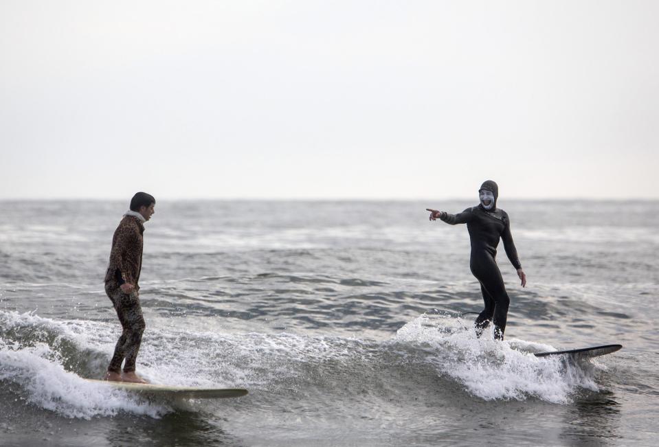 Participants surf during the third annual Rockaway Halloween surf competition at Rockaway Beach in the Queens borough of New York