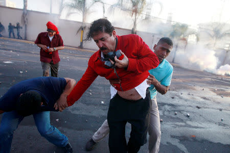 FILE PHOTO: Former President Manuel Zelaya is helped by aides while being overcome by tear gas during a protest against the re-election of Honduras' President Juan Orlando Hernandez in Tegucigalpa, Honduras, January 12, 2018. REUTERS/Jorge Cabrera/File Photo