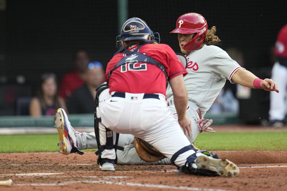 Philadelphia Phillies' Alec Bohm, right, is tagged out at home plate by Cleveland Guardians catcher David Fry (12) in the fourth inning of a baseball game Friday, July 21, 2023, in Cleveland. (AP Photo/Sue Ogrocki)