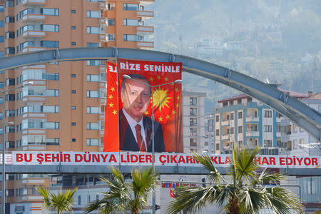 A huge portrait of Turkish President Tayyip Erdogan is seen above a banner that reads, "This city is proud of raising a world leader" in Rize on the Black Sea coast, Turkey, April 5, 2017. Letters on the portrait read "Rize is with you". Picture taken April 5, 2017. REUTERS/Umit Bektas