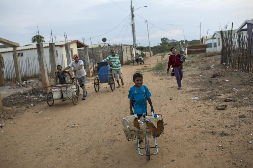 Residents, young and old, push drinkable water home in the Villa Esperanza neighborhood on the outskirts of Maracaibo, Venezuela, May 15, 2019. Much of Venezuela is in a state of decay and abandonment, brought on by shortages of things that people need the most: cash, food, water, medicine, power, gasoline. (AP Photo/Rodrigo Abd)