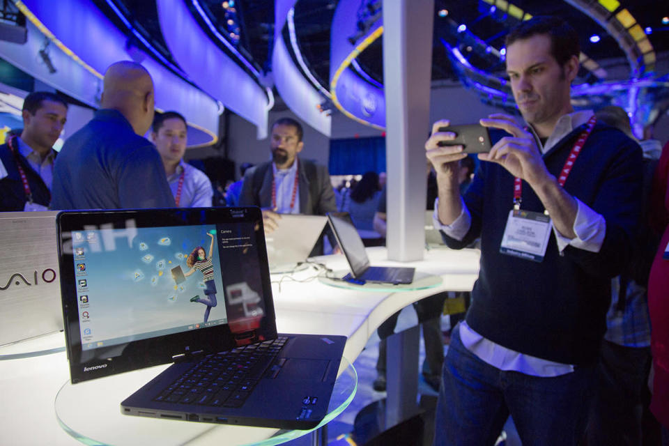 Convention goers photograph a Lenovo convertible Ultrabook at the Consumer Electronics Show.