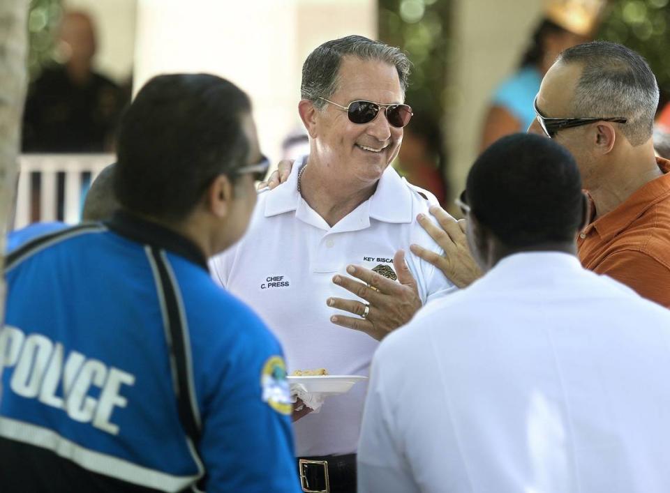 El jefe de policía de Key Biscayne, Charles Press (centro), habla con otros miembros del cuerpo policial durante la “Navidad en julio” en Village Beach Park, en Key Biscayne, el sábado 9 de julio de 2016.