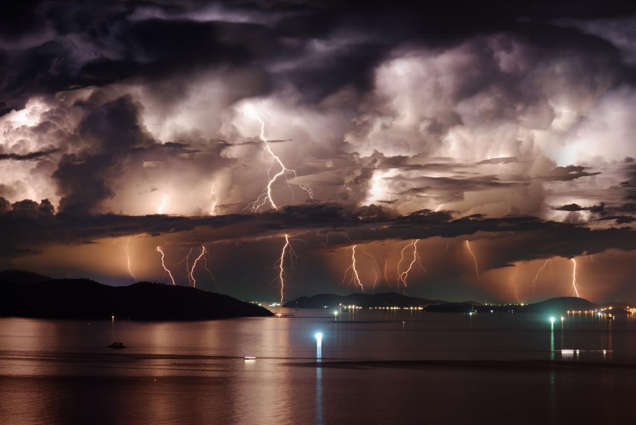 Beautiful view of dramatic dark stormy sky and lightning over Nha Trang Bay of South China Sea in Khanh Hoa province at night in Vietnam. Nha Trang city is a popular tourist destination of Asia.