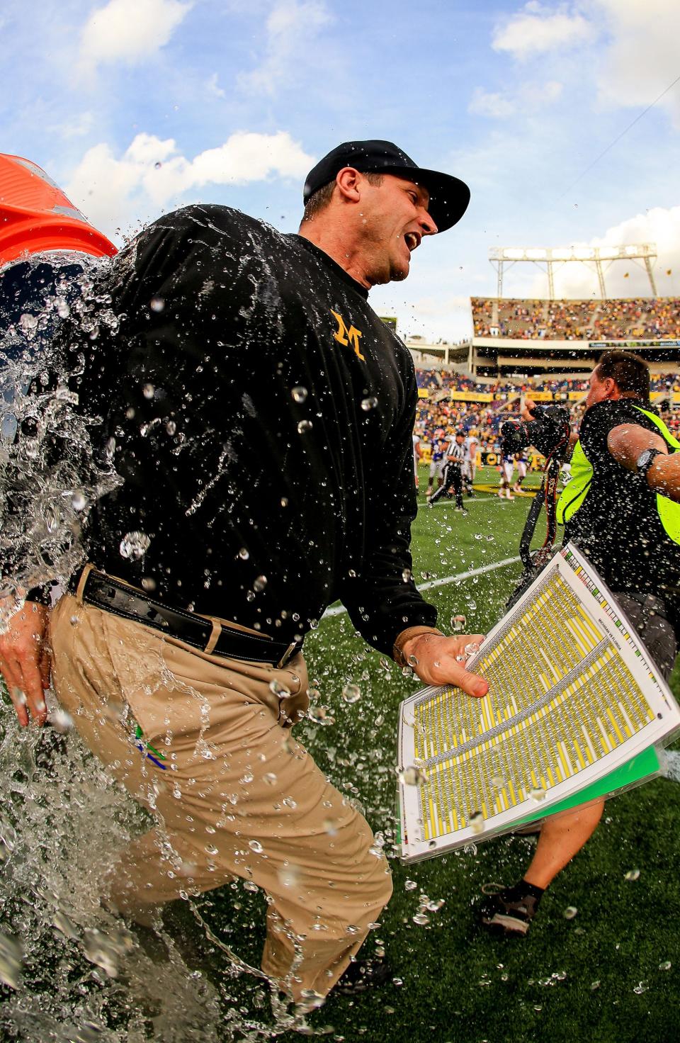 Michigan football coach Jim Harbaugh is dumped with water after the 41-7 win over Florida in the Buffalo Wild Wings Citrus Bowl on Jan. 1, 2016, in Orlando.