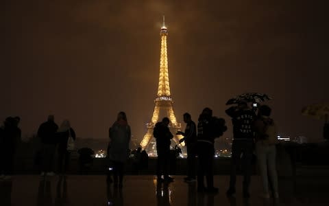 The Eiffel Tower is pictured in Paris before switching off lights  - Credit: AFP