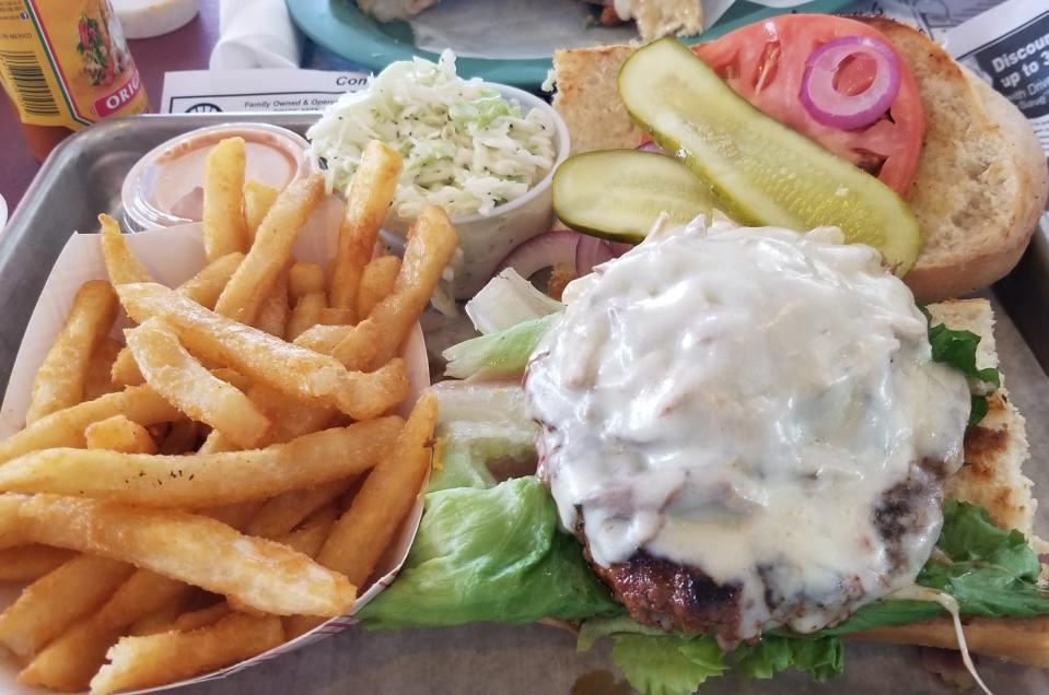 The Blackened Ybor Burger with Swiss cheese, shredded pork, grilled onions and Thousand Island dressing on toasted Cuban bread at J.R.’s Old Packinghouse Cafe in Sarasota.