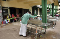 A member of an NGO cleans a cot outside the casualty ward at a hospital in Kozhikode in Kerala in the southern state of Kerala, India, May 23, 2018. REUTERS/Stringer