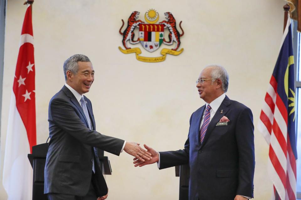 Singapore's Prime Minister Lee Hsien Loong, left, shakes hand with Malaysia's Prime Minister Najib Razak after a press conference in Putrajaya, Malaysia, Tuesday, Dec. 13, 2016. Malaysia and Singapore today signed the long-awaited agreement on the Kuala Lumpur-Singapore High Speed Rail (HSR) project. (AP Photo/Vincent Thian)