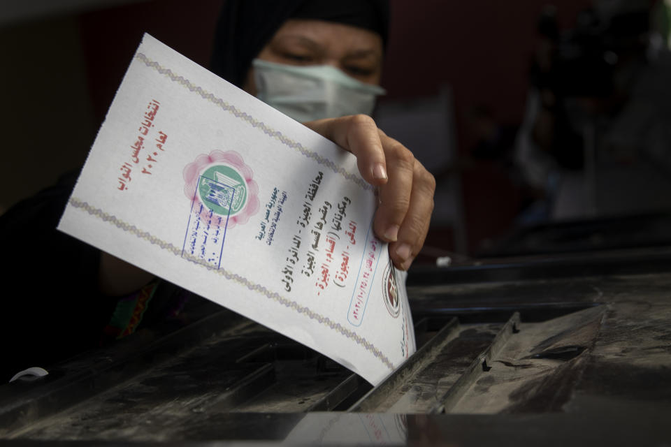 A woman casts her ballot on the first day of the parliamentary election inside a polling station in Giza, Egypt, Saturday, Oct. 24, 2020. Egyptians began voting Saturday in the first stage of a parliamentary election, a vote that is highly likely to produce a toothless House of Representatives packed with supporters of President Abdel-Fattah el-Sissi. (AP Photo/Nariman El-Mofty)