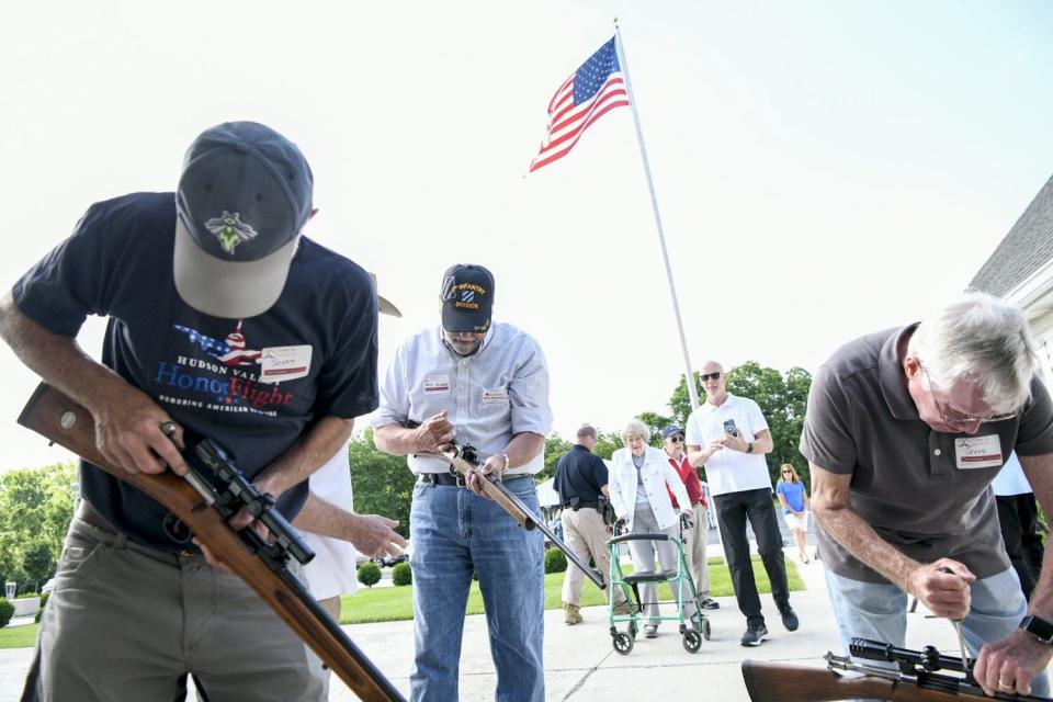 From left, volunteers Scott Toop, Steve Mushrush and Terry Davis begin to dismantle rifles June 11 at the Guns to Gardens event at the First Community Church North in Columbus.