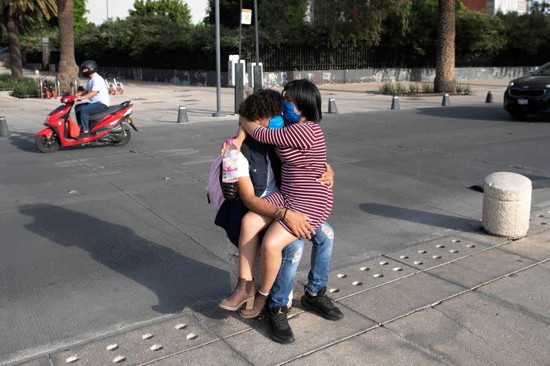 A couple is seen embracing on the street after Mexico's government declared a health emergency on Monday and issued stricter rules aimed at containing the fast-spreading coronavirus disease (COVID-19), in Mexico City