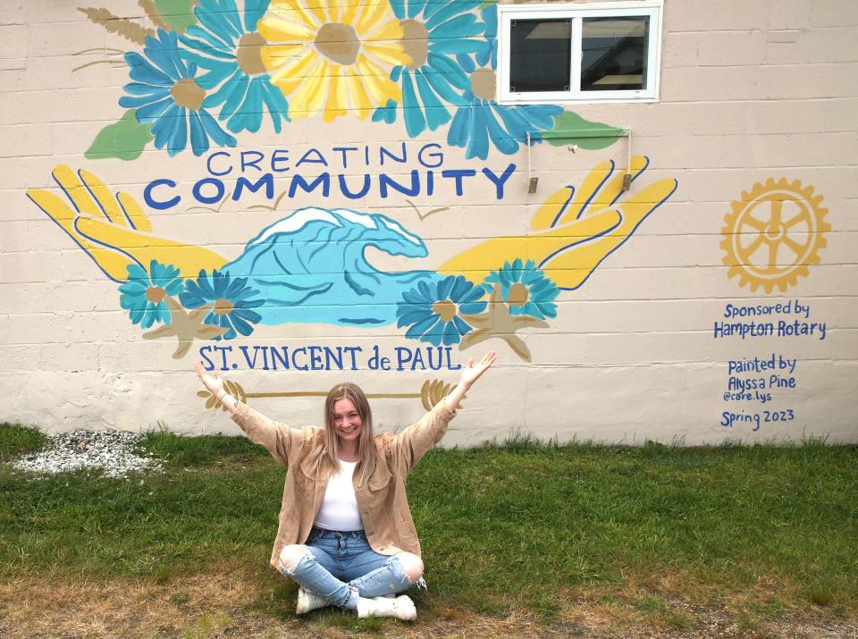 Artist Alyssa Pine shows off her latest mural on the side of St. Vincent de Paul's Community Kitchen and Clothes Closet in Hampton Tuesday, June 6, 2023.