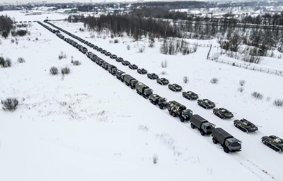 In this image taken from footage provided by the RU-RTR Russian television, Military vehicles of Russian peacekeepers are parked waiting to be uploaded on Russian military planes at an airfield in Russia, Friday, Jan. 7, 2022. Over 70 cargo planes are being deployed in Russia's peacekeeping mission in Kazakhstan according to the Defense Ministry chief spokesman's briefing on Friday, after the worst street protests since the country gained independence three decades ago. The demonstrations began over a near-doubling of prices for a type of vehicle fuel and quickly spread across the country, reflecting wider discontent over the rule of the same party since independence. (RU-RTR Russian Television via AP)