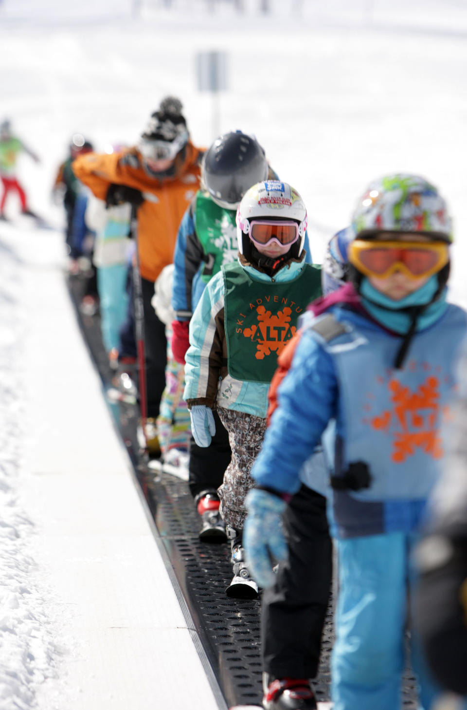 FILE - In this Feb. 19, 2013, file photo, young skiers ride the conveyor belt on Little Grizz at Alta Ski Resort in Little Cottonwood Canyon near Salt Lake City. Attorneys for the U.S. Forest Service say in court arguments filed this week that the decision by the Alta ski area in Utah to promote a snowboarder-free experience to lure skiers is a rational finding that violates no constitutional rights. Four snowboarders filed the lawsuit in federal court in January. They're claiming discrimination on national forest lands that make up most of the Alta ski area in the mountains east of Salt Lake City. (AP Photo/The Deseret News, Jeffrey D. Allred, File) SALT LAKE TRIBUNE OUT; MAGS OUT. MANDATORY CREDIT