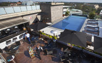 FILE - A member of staff wheels drinks at the rooftop pool of the Sankara Nairobi hotel in Nairobi, Kenya on Sept. 26, 2012. The ballooning debt in East Africa's economic hub of Kenya is expected to grow even more after deadly protests forced the rejection of a finance bill that President William Ruto said was needed to raise revenue. (AP Photo/Ben Curtis, File)