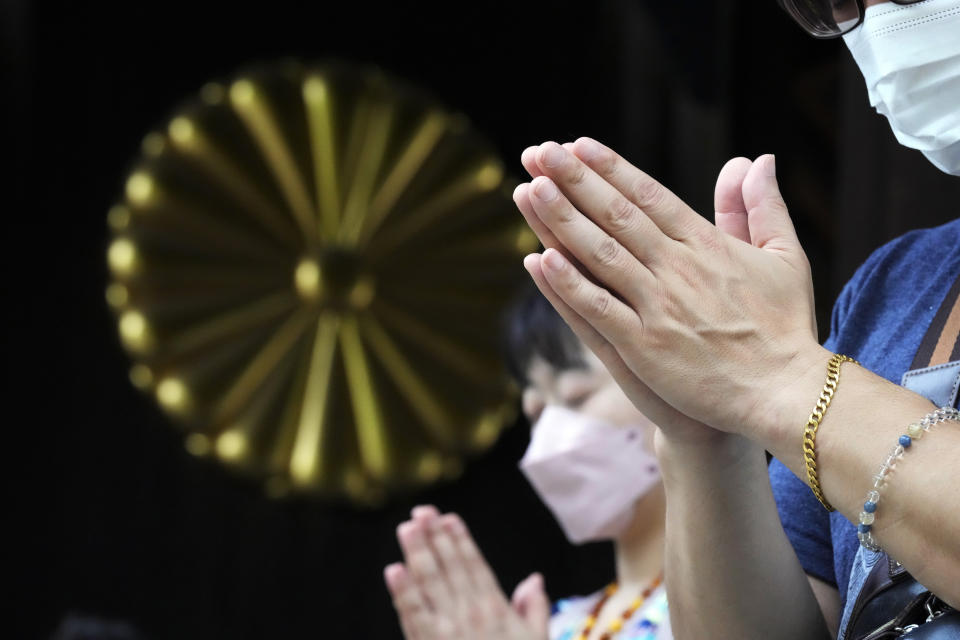 Visitors observe a minute of silence for paying respects to the war dead at Yasukuni Shrine Monday, Aug. 15, 2022, in Tokyo. Japan marked the 77th anniversary of its World War II defeat Monday. (AP Photo/Eugene Hoshiko)