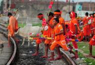 <p>Indian Hindu devotees of the deity Shiva cross a railway track at Daraganj railway station as they arrive to collect water from the Ganges river for their ritualistic walk towards Varanasi during the holy month of Shravan, in Allahabad on July 28, 2016. Shravan is considered the holiest month in the Hindu calendar with many religious festivals and ceremonies. </p>