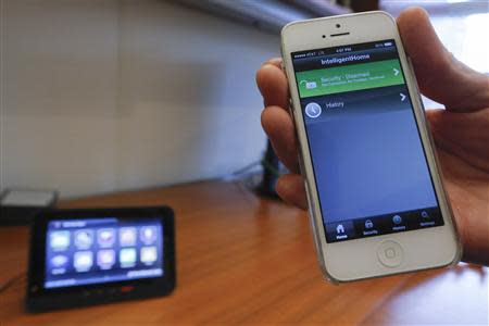 Time Warner Cable's "Intelligent Home" mobile app is held for demonstration at the Time Warner offices in New York, October 9, 2013. REUTERS/Shannon Stapleton