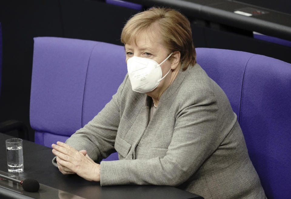 German Chancellor Angela Merkel attends a meeting of the German federal parliament, Bundestag, at the Reichstag building in Berlin, Germany, Wednesday, Nov. 8, 2020. German lawmakers attend a debate on a bill that will provide the legal underpinning for the government to issue social distancing rules, require masks in public and close stores and other venues to slow the spread of the virus. (Michael Kappeler/dpa via AP)