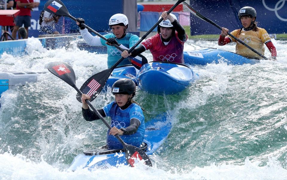 Kayak cross competitors  go down a descent