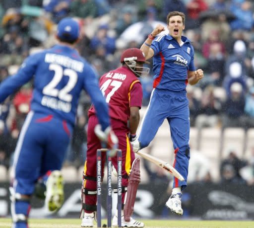 England's Steven Finn (R) celebrates taking the wicket of Dwayne Bravo of West Indies (C) for 8 runs. England beat the West Indies by 114 runs under the Duckworth/Lewis method