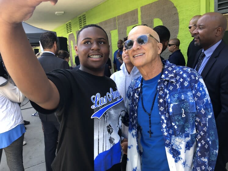 Ninth grader Jaylen Bell, left, takes a selfie with music industry mogul Jimmy Iovine, who co-founded the new Iovine and Young Center Integrated Design, Technology, and Entrepreneurship Magnet, located in Leimert Park in South Los Angeles. Iovine and the other co-founder, Andre "Dr. Dre" Young, attended the official grand opening of the school on Thursday, Aug. 18, 2022 and met with students. The first day of classes was Aug. 15.