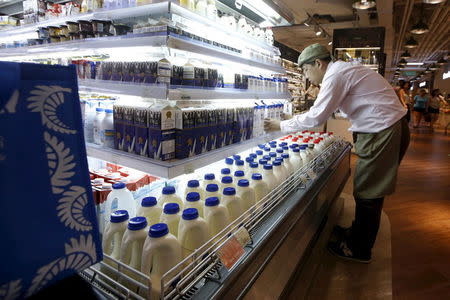 A salesman arranges milk products imported from Australia at a supermarket inside IAPM mall in Shanghai, China, August 15, 2015. REUTERS/Aly Song